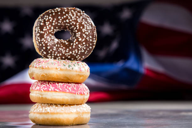 istock Various donuts and a gift over american flag. Happy holiday background 1128704981