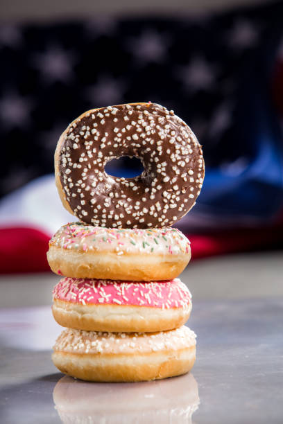istock Various donuts and a gift over american flag. Happy holiday background 1128704994