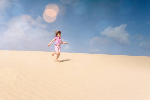 istock Beautiful child playing in the dunes 1128707993