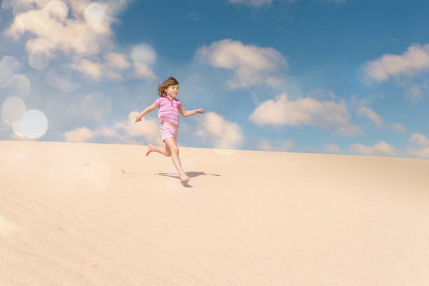 istock Beautiful child playing in the dunes 1128708638