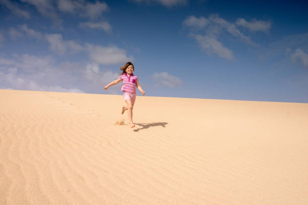 istock Beautiful child playing in the dunes 1128709098