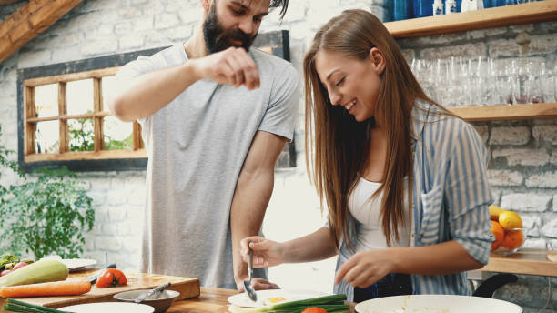 istock Young couple making dinner together at home 1128709371