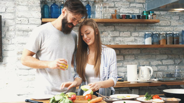 istock Young couple making dinner together at home 1128709374