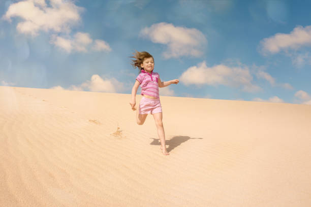 istock Beautiful child playing in the dunes 1128709393