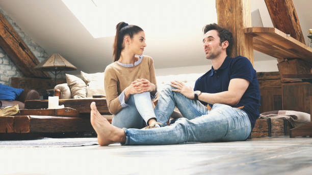 istock happy couple talking to each other at home 1128709419