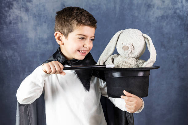 маленький фокусник делает трюк с кроликом - rabbit child pets little boys стоковые фото и изображения