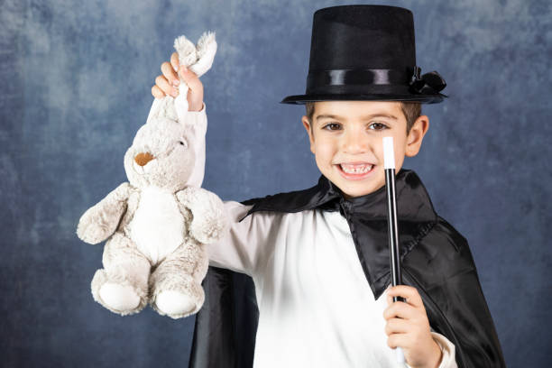 Little magician doing a trick with a rabbit Little magician doing a trick with a rabbit wizard photos stock pictures, royalty-free photos & images