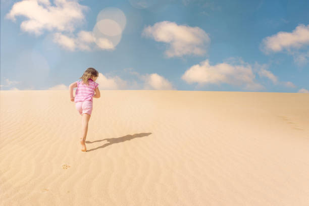 istock Beautiful child playing in the dunes 1128711524