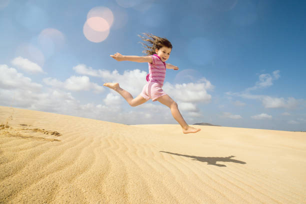 istock Beautiful child playing in the dunes 1128712639