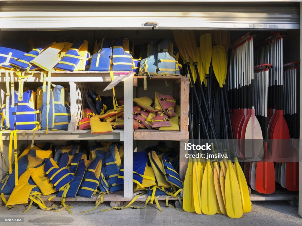 Stacked Life Vests And Kayak Paddles Storage Unit Stock Photo