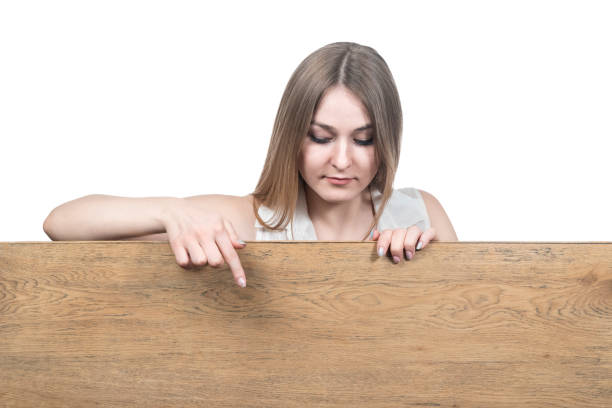 istock woman points down to a wooden board 1128715679
