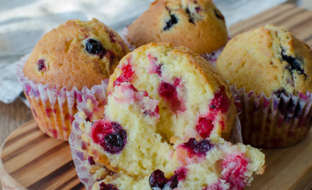 istock Muffins with red and black currant. paper bakeware with Valentine's day design with pink hearts. Close up, angle view 1128715735