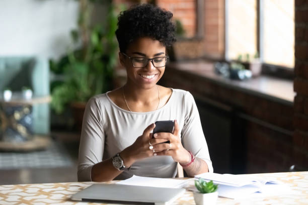 istock Black woman sitting at table take a break surfing internet 1128717599