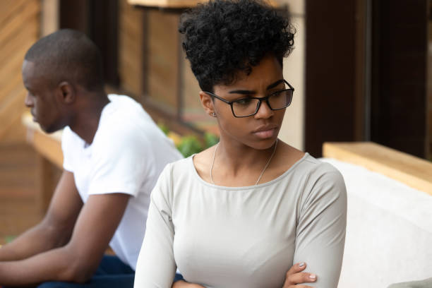 istock Black unhappy couple sitting on sofa separately at each other 1128717732