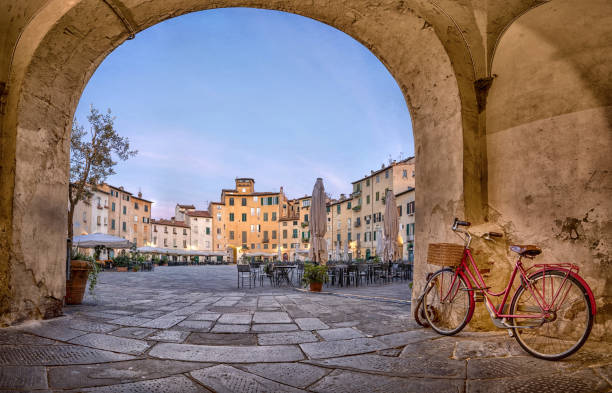 Lucca, Italy. View of Piazza dell'Anfiteatro square Lucca, Italy. View of Piazza dell'Anfiteatro square through the arch lucca italy stock pictures, royalty-free photos & images