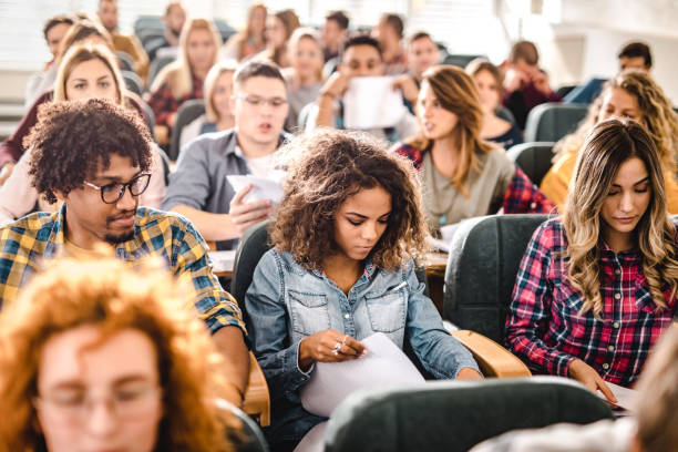 istock Large group of young college students in a lecture hall. 1128723345