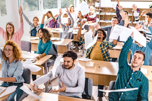 istock Large group of cheerful students having fun while celebrating the end of a class in the classroom. 1128725857