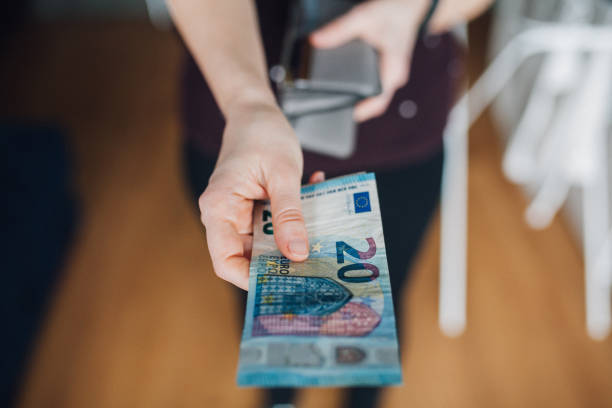 istock Woman paying with cash 1128725936
