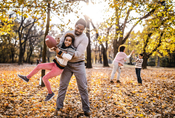 istock Playful black family having fun while playing rugby in the park. 1128726774