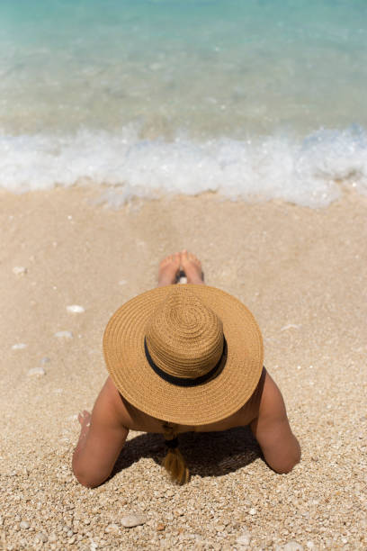 istock Woman in summer hat on beach 1128727297