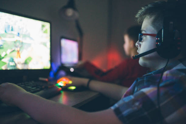 два мальчика играют в онлайн игры - teenager video game gamer child стоковые фото и изображения
