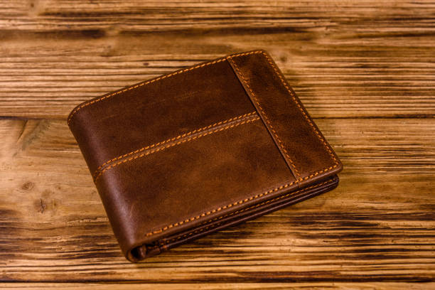 istock Closed brown leather wallet on wooden table 1128731952