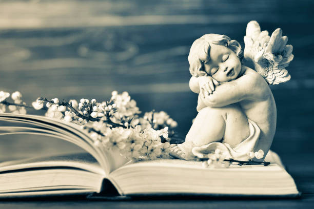 istock Angel and spring flowers on the book 1128732875