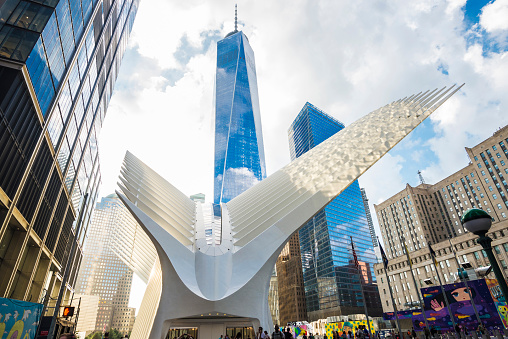 New York City, USA - July 26, 2018: World Trade Center station (PATH), a new transit hub in lower Manhattan called the Oculus, designed by Santiago Calatrava, next to skyscrapers like One World Trade Center with people around in New York City, USA