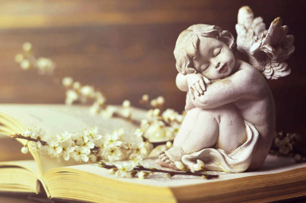 istock Guardian angel and spring branches on the book 1128733052