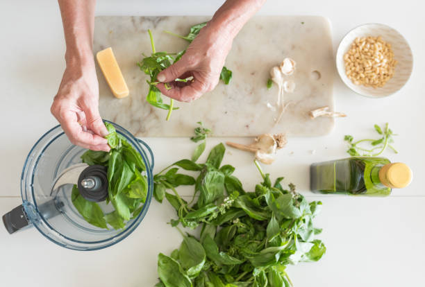 mujer manos preparación de albahaca de pesto de arriba - food processor fotografías e imágenes de stock