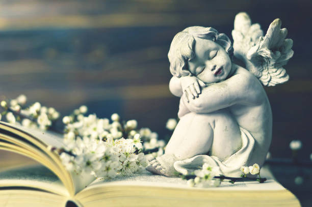 istock Guardian angel and spring flowers on the book 1128733070