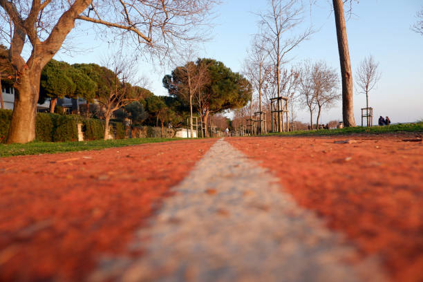 Jogging Track Close-up of orange, soft jogging lane in urban park outdoor. A healthy city lifestyle background. çim stock pictures, royalty-free photos & images