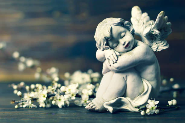 istock Angel and spring branches on wooden background 1128734344
