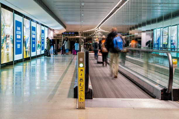Dublin, Ireland - January 2019 Dublin airport, people rushing for their flights, long corridor with moving walkway, motion blur stock photo