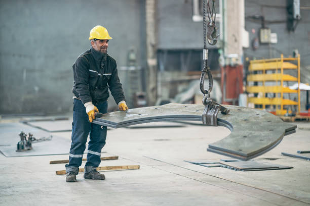 istock Silhouette of man using chain hoist in workshop. 1128735415