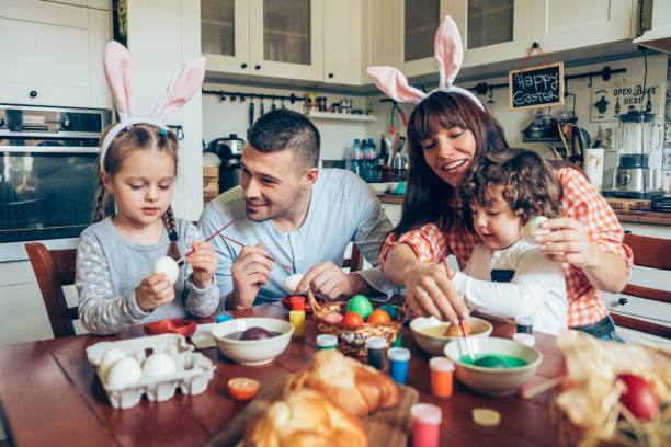 Happy family painting Easter eggs Lovely family prepare for Easter at domestic kitchen coloring photos stock pictures, royalty-free photos & images
