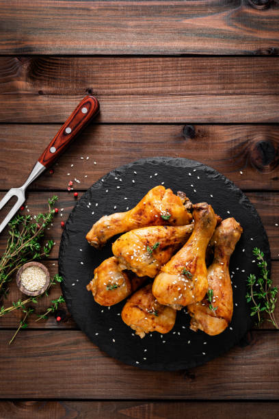 istock Grilled chicken legs on wooden background. Top view 1128738802