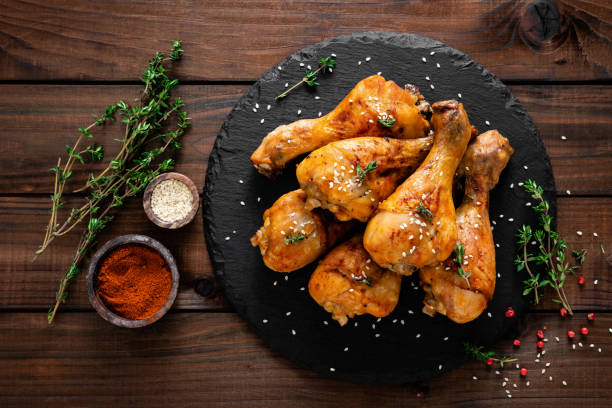 istock Grilled chicken legs on wooden background. Top view 1128738966