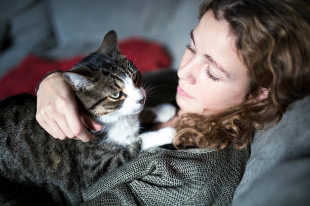 istock Beautiful young woman with her cat on a sofa 1128740020