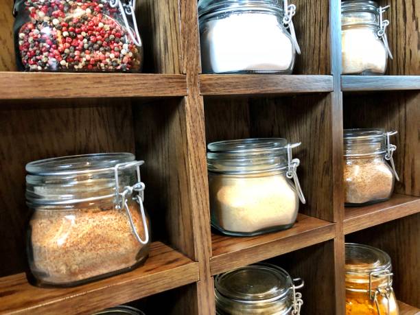 Large spice jars displayed in wooden case