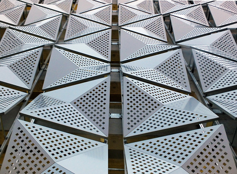 modern steel angular geometric cladding in perspective with shiny silver colour and perforated patterned design
