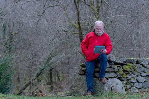 senior man using a digital tablet - fleece coat imagens e fotografias de stock