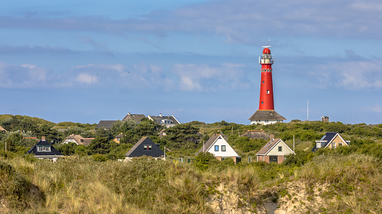 Red lighthouse between houses of village of Schiermonnikoog