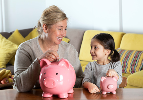 Grandmother and granddaughters with piggy bank.