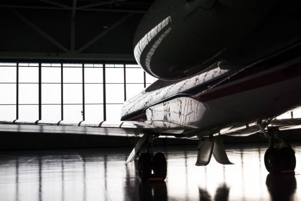 business jet in hangar - hangar foto e immagini stock