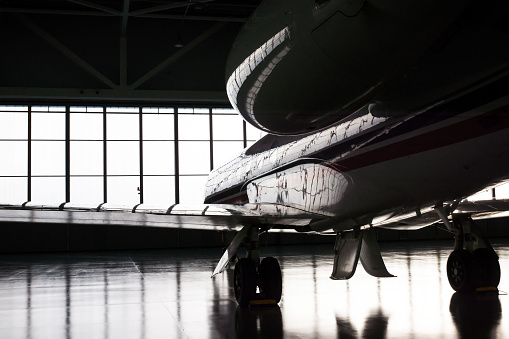 Luxorious business jet plane being stored inside the hangar