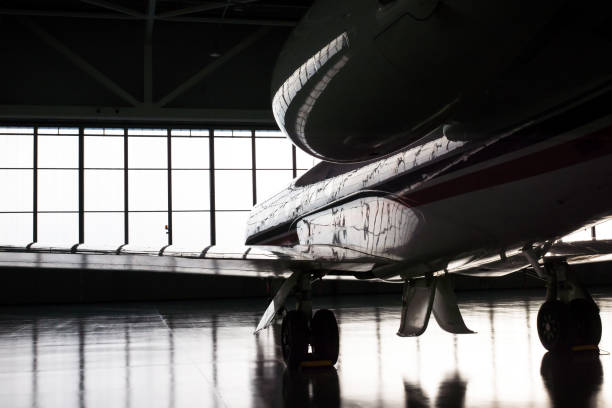Business Jets in Hangar Luxorious business jet plane being stored inside the hangar airplane hangar stock pictures, royalty-free photos & images