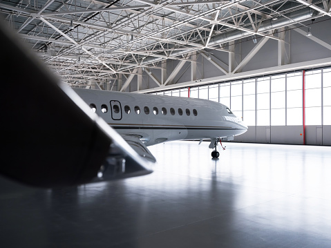 Luxorious business jet plane Dassault Falcon is being stored inside the hangar