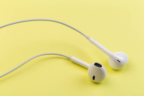 istock white earphones on yellow background 1128747418