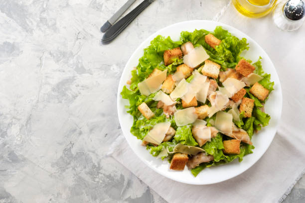 istock Caesar salad with chicken and herbs on the table, Caesar sauce, Parmesan cheese 1128748969